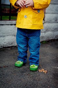 身穿黄色雨衣的小孩子特写图片
