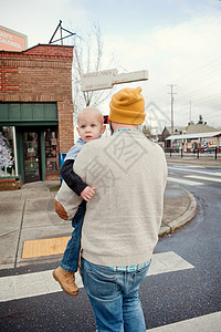 父亲带小儿子横跨行人交叉口图片