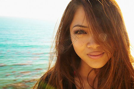 在海边微笑的年轻女子肖像图片