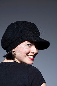 戴着黑帽子微笑的年轻女性肖像图片