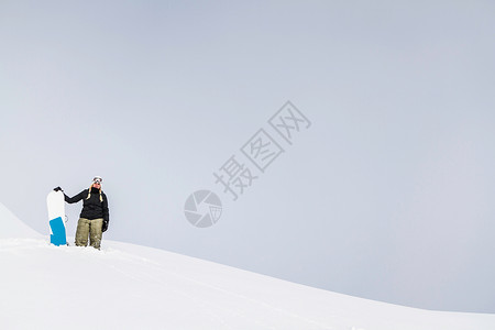 布朗伯格阿姆威尔德科格尔酒店拿着雪板站在雪地上的女运动员背景