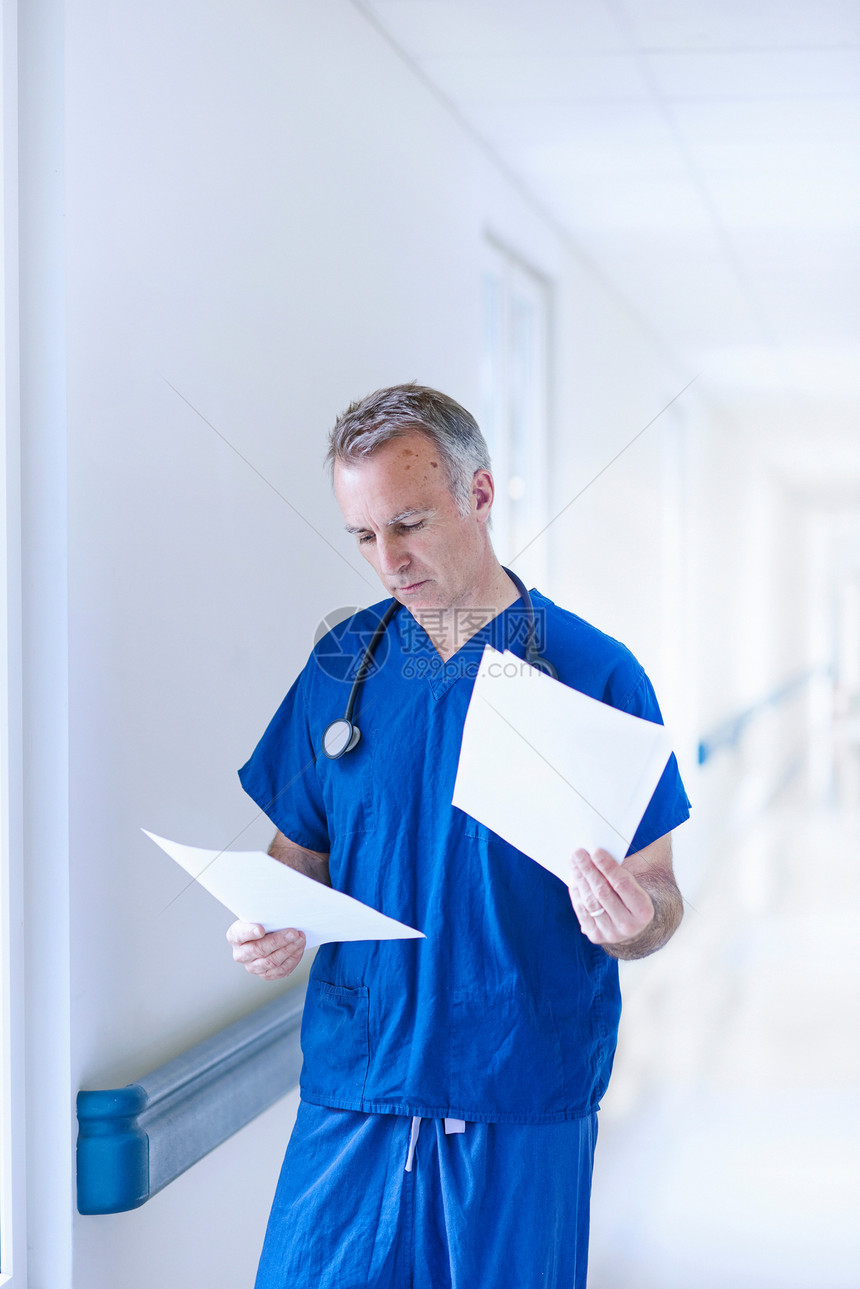 站在走廊看病人记录的医生图片