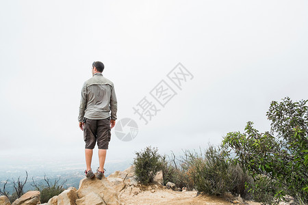 山顶上的中年男性的后视图图片