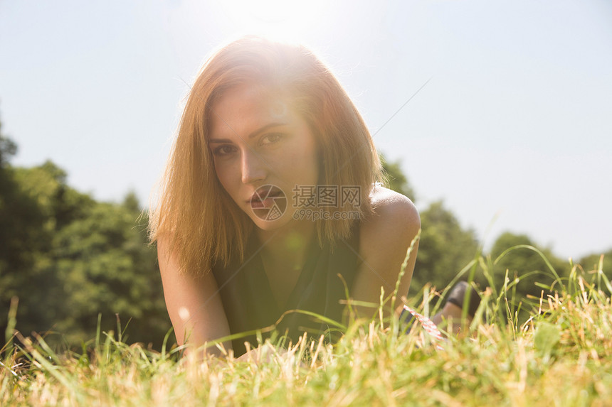 年轻女人在阳光下的公园里放松图片
