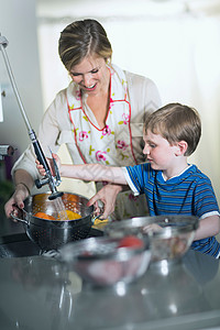 母亲和儿子在厨房里清洗蔬菜图片
