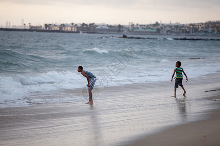 两个男孩在海滩玩耍图片