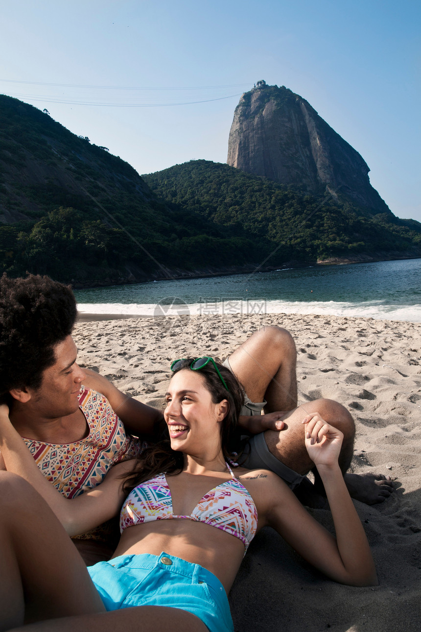 年轻情侣在海滩上放松图片