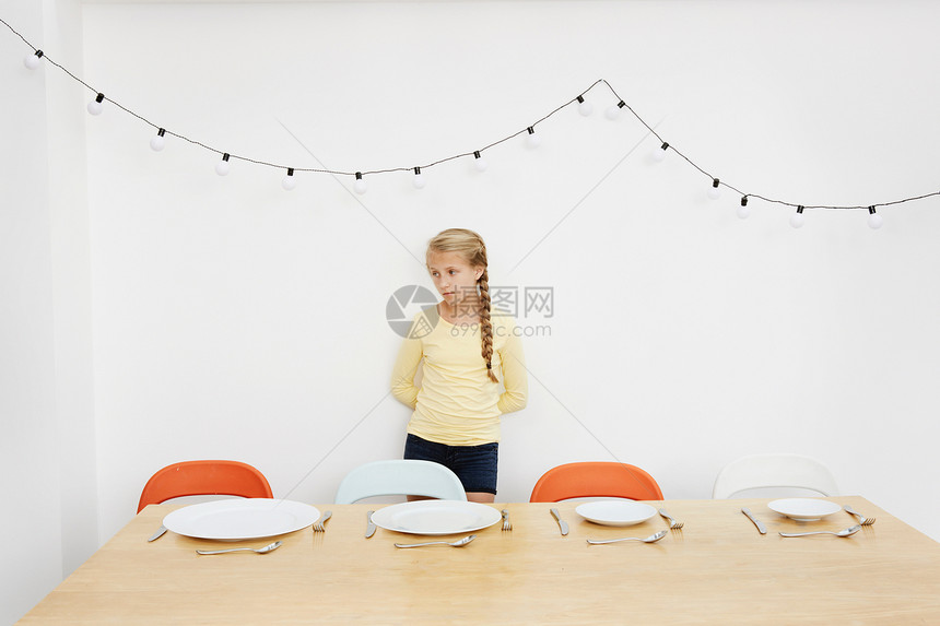 女孩站在餐桌前等待家人一起图片