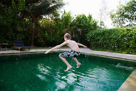 男孩跳进游泳池图片