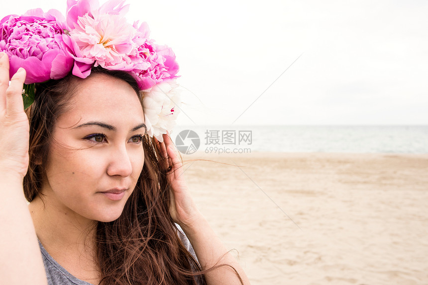 年轻女人在沙滩上头发上插着鲜花图片