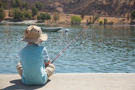 男孩在湖边捕鱼图片