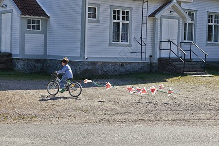 骑自行车的男孩拉着小旗子图片