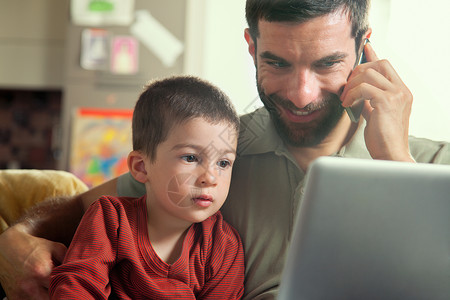 父亲和儿子看笔记本电脑图片