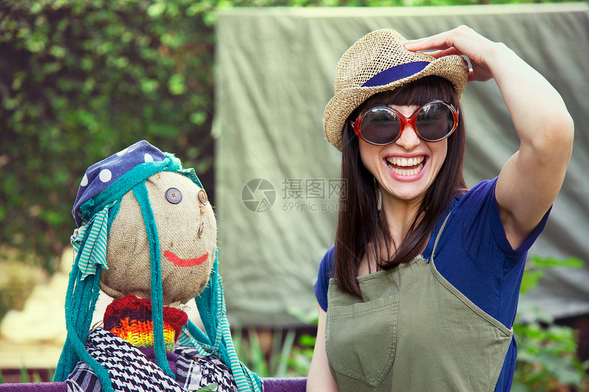 戴太阳眼镜和稻草人帽子的妇女图片