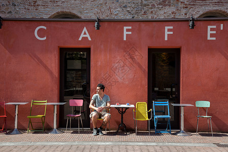坐在咖啡馆外的男子图片