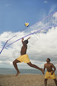 朋友在海滩玩排球高清图片