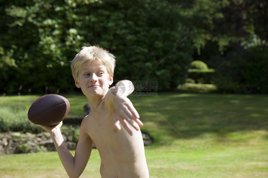 在花园扔橄榄球的男孩图片