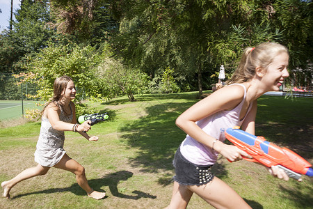 斗殴在花园玩水枪的女孩背景