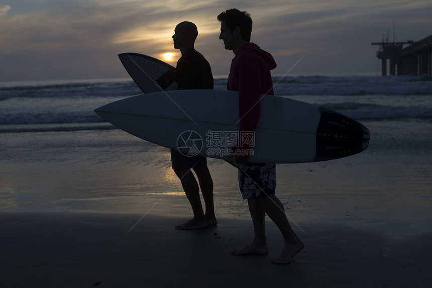  两个男人携带冲浪板在海滩上 图片