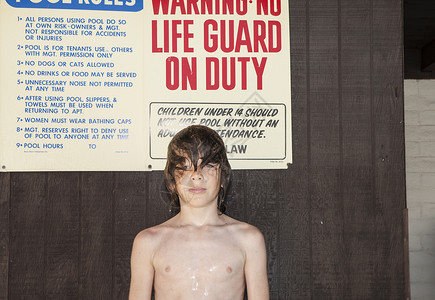 站在小屋前面毛发湿漉漉的男孩图片