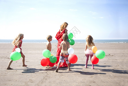 海滩上带着气球玩耍的孩子与母亲图片