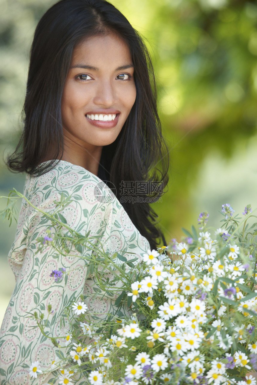 手捧鲜花微笑的亚洲女性图片