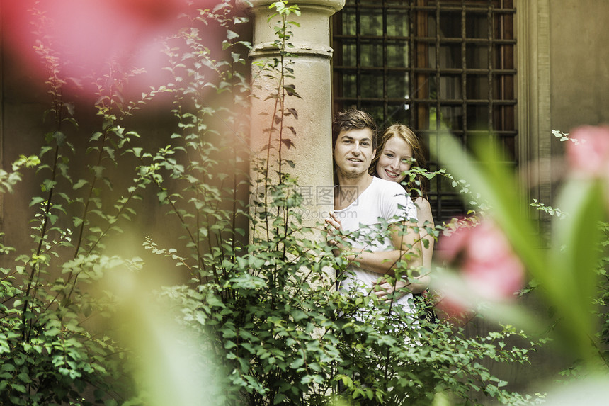 年轻夫妇站在花园的柱子上图片