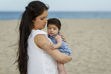母亲在海滩上抱着婴儿高清图片