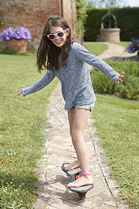 女孩在花园里滑滑板背景图片