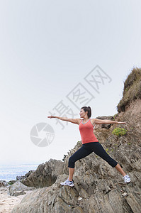 在岩石上做瑜伽运动的女人图片