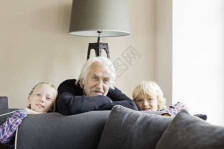 靠在沙发上的祖父和孙辈肖像图片