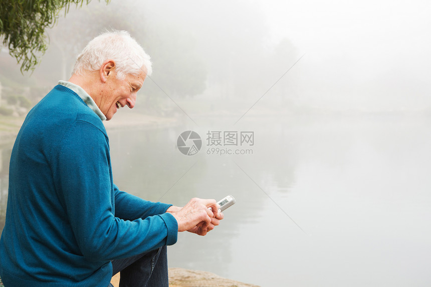 老年人看着手机上的短信微笑图片
