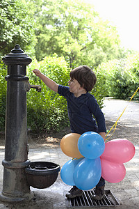 小孩好奇地看花园里的水泵图片