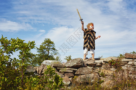 白天剑突在海边拿着木剑玩耍的孩童背景
