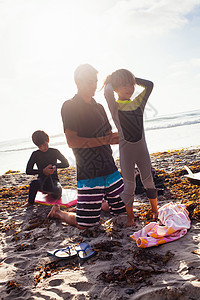 美国加利福尼亚恩西塔斯海滩上准备冲浪的父亲和孩子图片