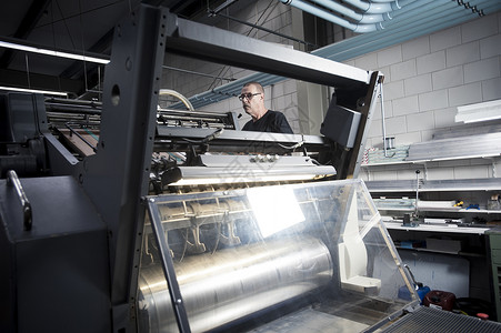 印刷车间工人操作印刷机高清图片