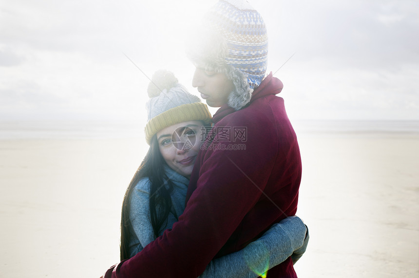 在沙滩上拥抱的年轻夫妇图片