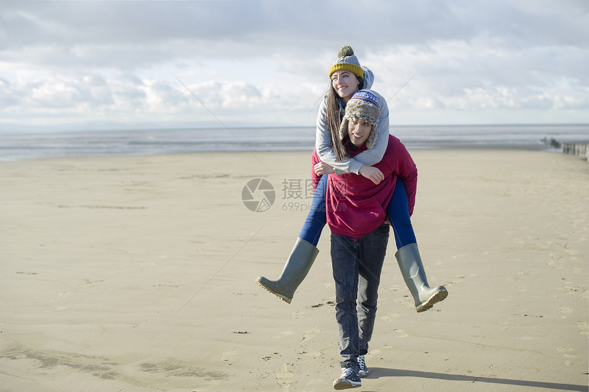 在布赖恩沙地萨默塞特英格兰的沙滩上男人背着女人图片