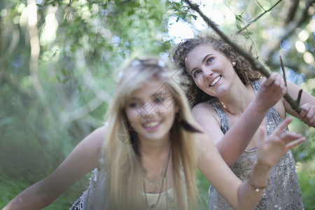 两个少女在林地玩耍细枝高清图片素材