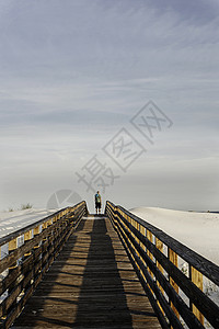 美国阿拉巴马湾海岸高木行走道上的年轻人图片