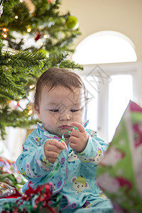 婴儿女孩在圣诞节开礼物图片