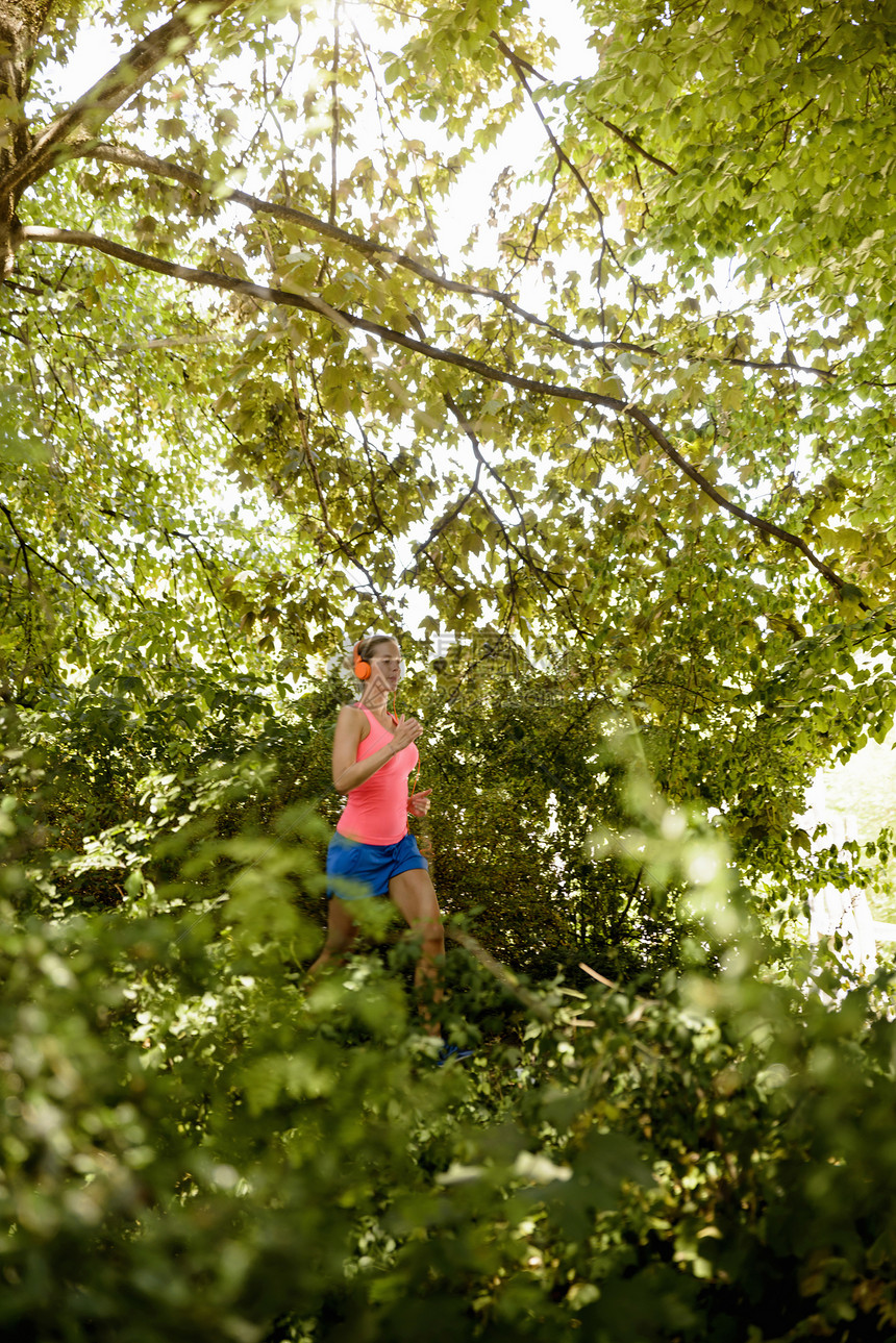 年轻妇女在树林中奔跑图片
