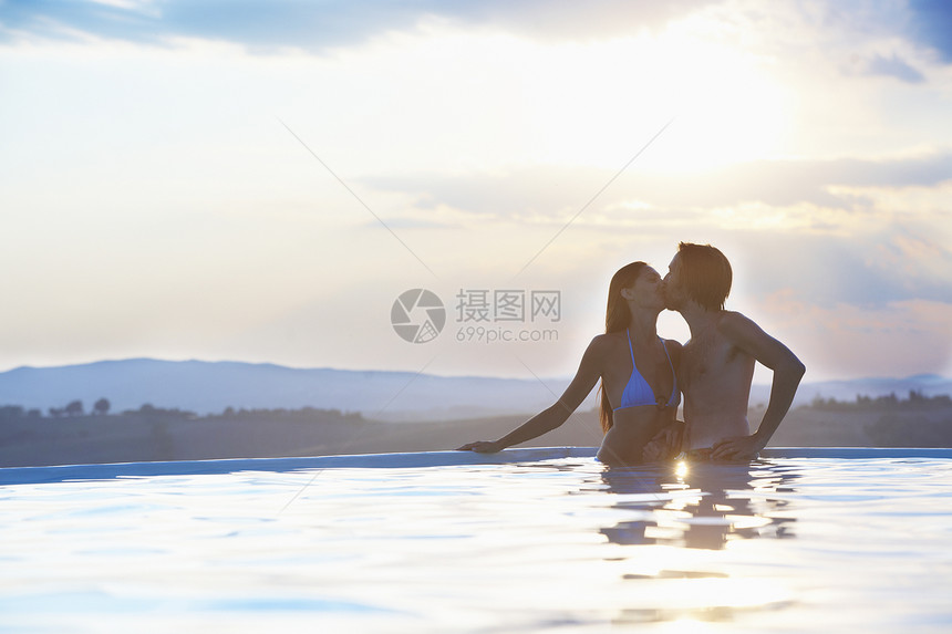 浪漫夫妇在户外游泳池亲吻图片
