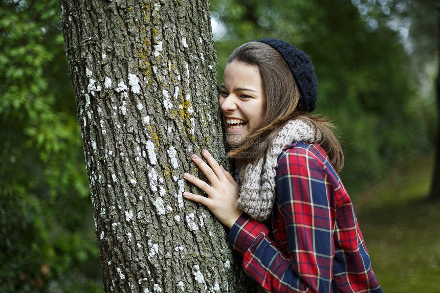 森林中靠着树的少女图片
