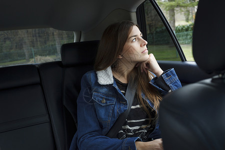 坐在车里向外看的年轻女性图片