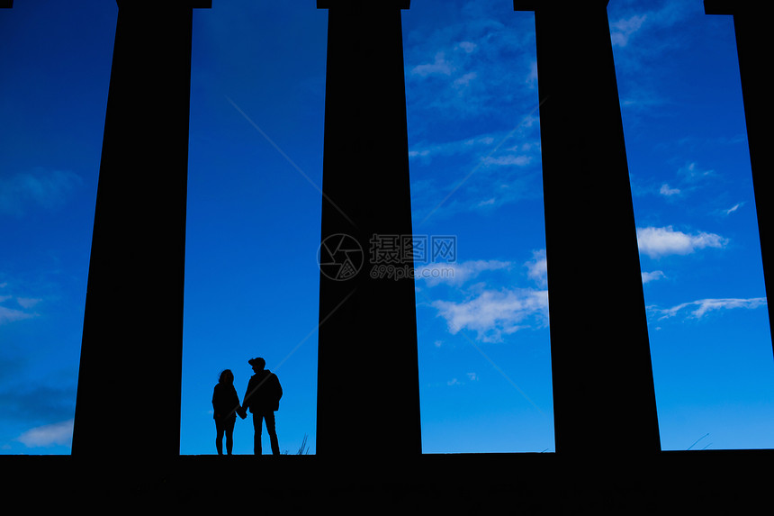 一对年轻夫妇在爱丁堡苏格兰纪念碑前握手图片
