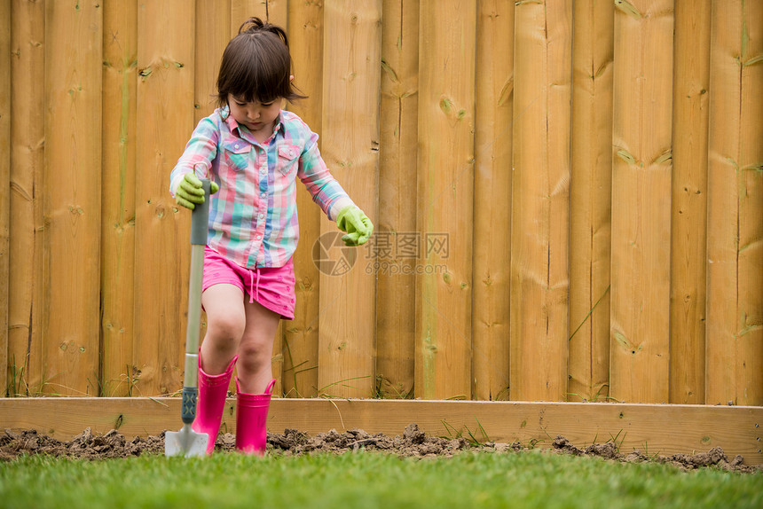 在花园里挖土的年轻女孩图片