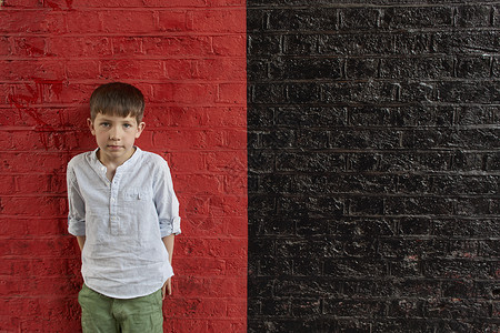 男孩对抗红墙和黑图片