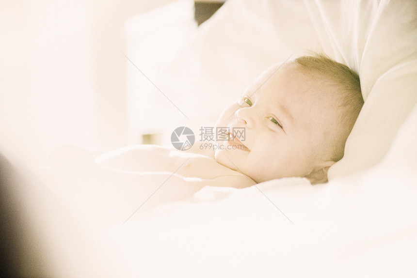 躺在婴儿床的微笑男孩图片
