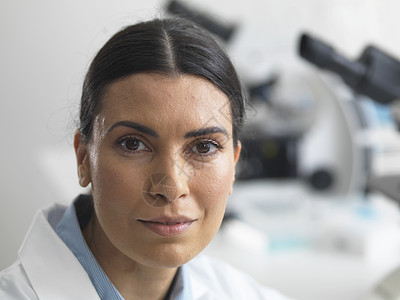 女研究员在显微镜旁边的实验室图片
